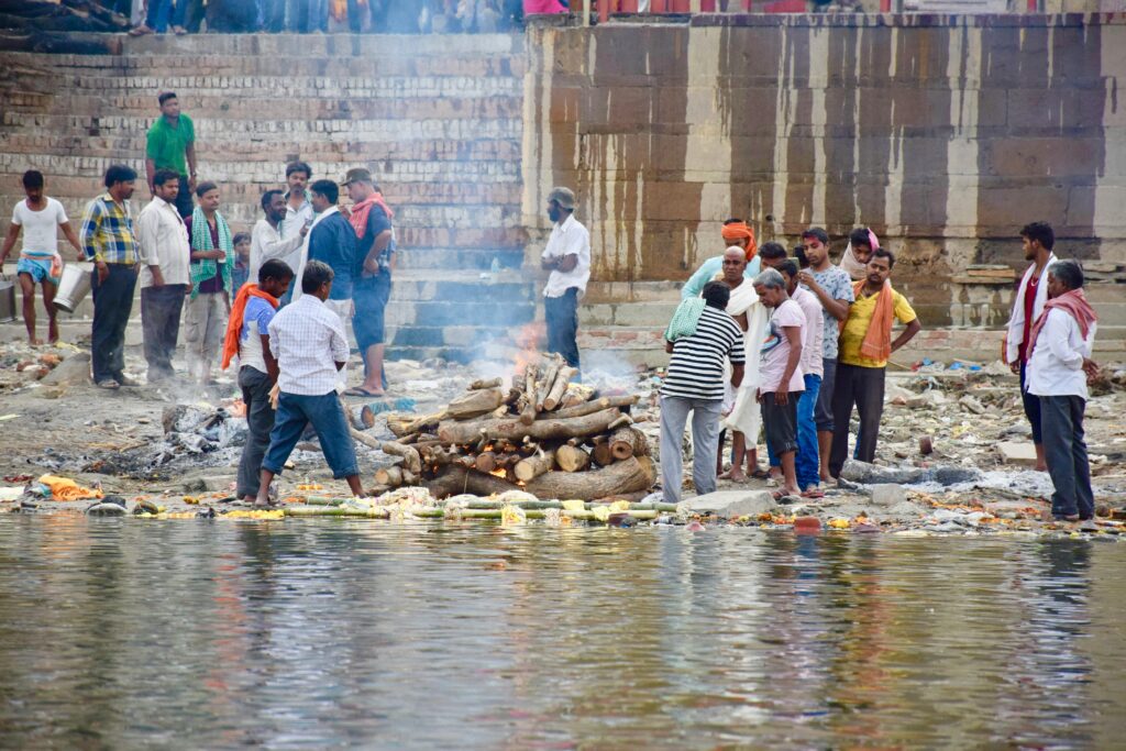 A group of people participate in a traditional ceremony by the Ganges River in Varanasi, India.